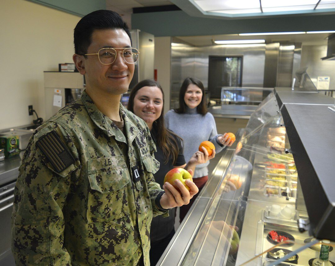 Nutrition instructor demonstrating healthy meal preparation to students
